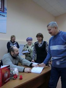 Составитель сборника Станислав Петров подписывает экземпляры книги